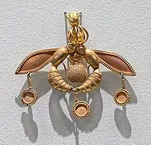 Pendentif en or représentant deux abeilles transportant une goutte de miel. Malia, Musée archéologique d'Héraklion.