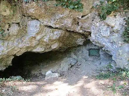 Entrée murée de la grotte du Chevalet petit abri à sa gauche.