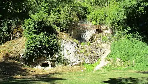 Sur la butte, grotte du Renne à droiteet grotte du Bison à sa gauche sous le lattis rouge.