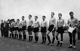 Photo noir et blanc de l'équipe d'Argentine en maillot clair et short noir alignée au moment de la présentation de début de match.