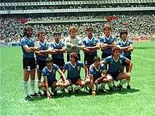 Photographie en couleurs. Les joueurs argentins, légèrement à contre-jour, posent avec sept joueurs debout et quatre devant eux, accroupis.