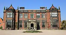 A large mansion in Jacobethan style, viewed from the front