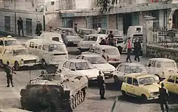 photo d'un blindé accompagné de militaires en armes surveillant un embouteillage.