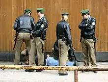 quatre policiers portant une casquette verte.