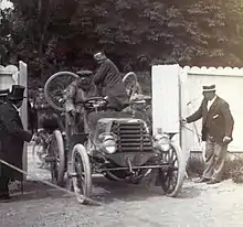 Photo d'une voiture roulant entre deux palissades.