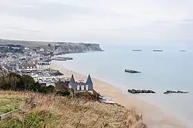 Arromanches-les-Bains vue de l'est, avec les vestiges du port Mulberry dans sa baie, dans le nord.