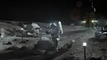 Un astronaute mine une grande pierre à la surface de la Lune.