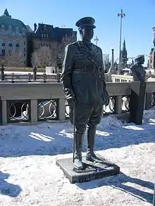 Statue d'un militaire devant des bâtiments.
