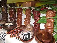 Photo de statuettes de tikis en bois et d'autres objets artisanaux.