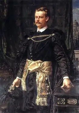 Portrait peint en couleurs d'un aristocrate à la figure expressive portant de longues moustaches blondes pose en habits officiels, une tunique noire brillante ceinte à la taille par une large écharpe de soie beige brodée.