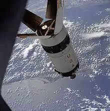 Un étage de fusée flottant dans l'espace, vu depuis un vaisseau spatial.