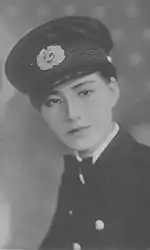 Photo portrait noir et blanc d'une femme qui porte un uniforme et casquette d'un officier militaire.