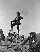 Photographie en noir et blanc d'un homme au sommet d'une montagne.