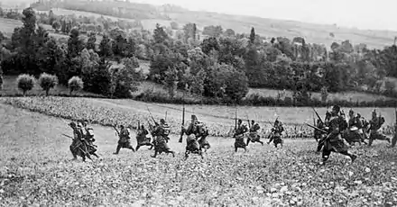 photographie en noir et blanc de soldats français courant dans un champ