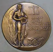 Médaille représentant une femme, debout, un parchemin à la main.