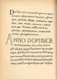 Une page manuscrite écrite en petites capitales, avec une grande inscription « Anno Dominicæ » au centre de la page