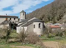 Photo de l'église de l'Assomption : vue extérieur du chœur, le clocher et l'entrée étant de l'autre côté de l'édifice. Les murs sont gris et le toit est fait en ardoise.