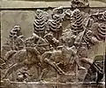 Cavaliers assyriens traversant une forêt.