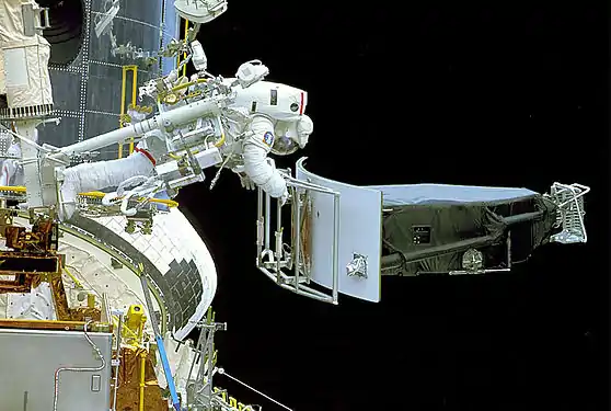 Jeffrey Hoffman manipule l'instrument WF/PC1 qui vient d'être retiré du télescope spatial Hubble