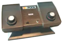 Photo d'une console de salon Pong, avec deux paddles incrustés sur la machine.