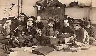 Atelier de brodeurs et de brodeuses de la maison Pichavant à Pont-l'Abbé (carte postale collection Villard), France, vers 1909.