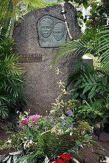 Photo montrant la tombe de Jacques Brel. Son visage est sculpté dans un médaillon.