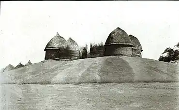 Photographie de l'Aturwic, quatre huttes sur une colline