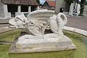 Vue latérale: les ailes de dragon et les pattes de griffon.