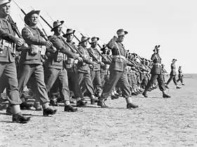 Photo en noir et blanc d'une troupe militaire effectuant un défilé.