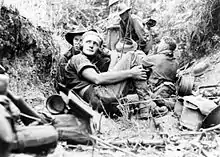 Photo noir et blanc de six militaires. Au centre est assis le radio, les quatre autres sont assis ou accroupis.