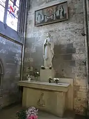 Photo de l'autel qui sert de socle à une statue de la Vierge et surmonté au mur d'un tableau
