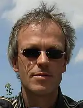 Photo en couleur d'un homme portant des lunettes de soleil.