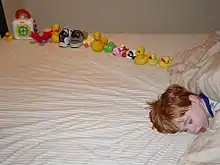 Jeune garçon endormi à côté de jouets