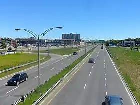 Photographie couleur d'une autoroute avec quelques voitures.