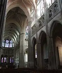 Les trois niveaux d'élévation de la nef. Les colonnes des grandes arcades sont dépourvues de chapiteaux, à l'inverse de celles du chœur ici en arrière-plan.