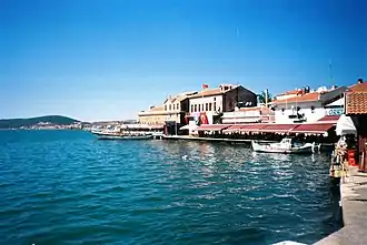 photographie couleurs d'un port : un quai et des maisons au bord de l'eau