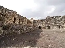 cour nue bordée de deux murailles de pierre