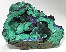 Vacuole avec rosaces d'azurite bleu profond sur un champ de malachite.