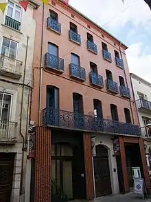 photographie d'un bâtiment rouge à trois étages