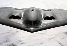 Vue de face d'un B-2 en vol. L'appareil est particulièrement plat
