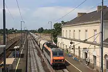 Vue, depuis la passerelle de la gare de La Possonnière, d'un train de fret de céréales.