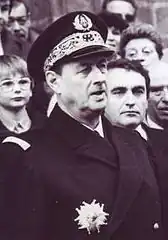 Photographie noir et blanc d'un amiral en buste lors d'une assemblée portant la plaque de Grand officier de la légion d'honneur.
