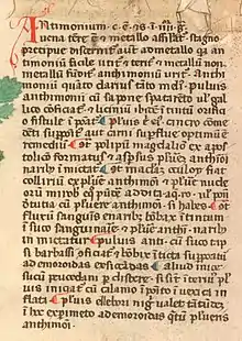 Détail d'une page de manuscrit contenant un bloc de texte en gothique à l'initiale A rouge et montrant plusieurs pieds-de-mouche rouges et bleus en alternance.