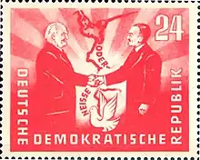 1951 : poignée de main entre les présidents des deux pays, Wilhelm Pieck (RDA) et Bolesław Bierut (Pologne), au-dessus d'une représentation de la frontière