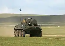 Photo représentant un véhicule de combat dans une plaine de Mongolie, participant aux exercices militaires dans le cadre de Khaan Quest
