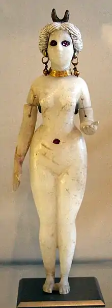 Statuette en albâtre d'une femme nue avec de petites cornes sur la tête.