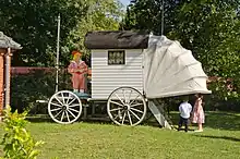 La roulotte possède 4 roues, une cabine cubique en bois avec une petite fenêtre, une partie entoilée pouvant se déplier jusqu'au niveau de l'eau et un petit escalier pour descendre se baigner.