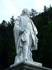 Photographie d'une statue en marbre blanc sur un piedestal.