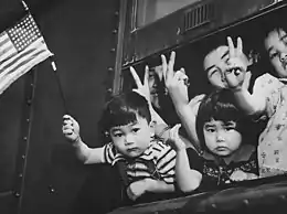 Un groupe de jeunes évacués à la fenêtre d'un train spécial alors qu'il quitte Seattle avec les évacués de l'île de Bainbridge, le 30 mars 1942.