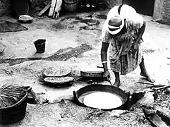 Préparation de la kesra sur un tajine traditionnel à pain, Algérie 1962.